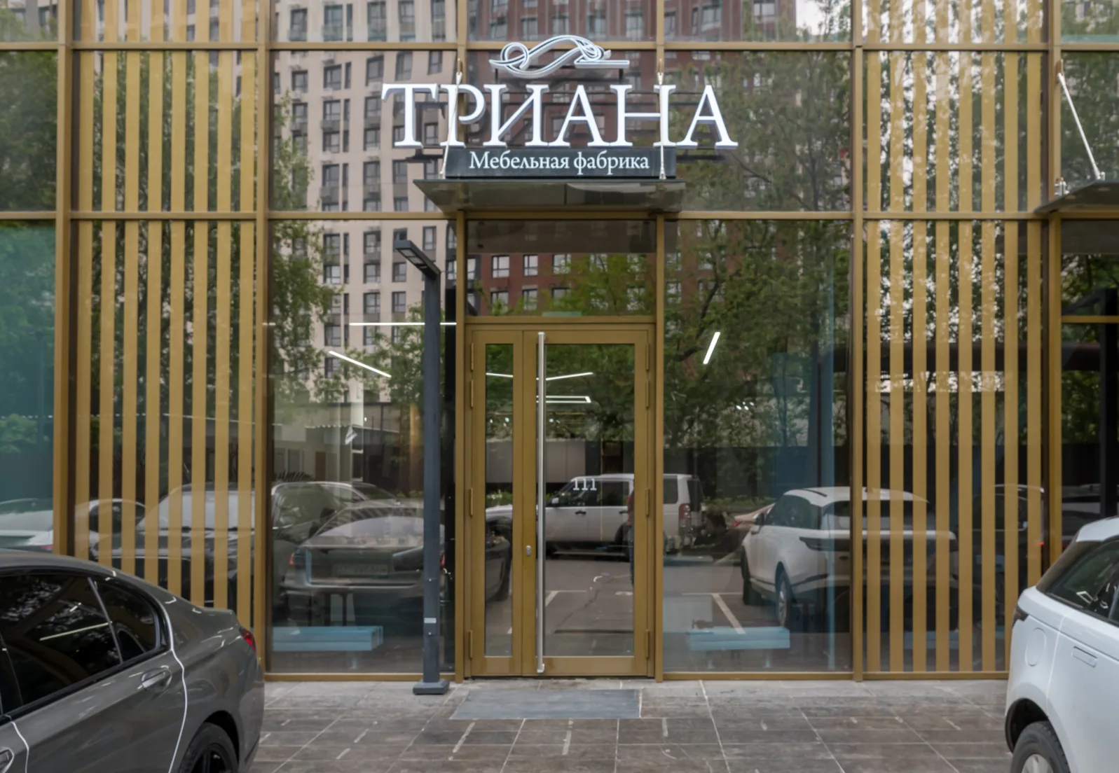 Стеклянный вход в шоурум с вывеской ТРИАНА
